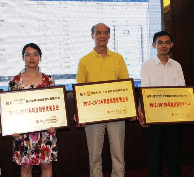 图4、广东宏陶陶瓷有限公司被授予“2012—2013年佛山陶瓷科技创新优秀企业”称号，该企业副总经理欧家瑞（中）接受颁奖.jpg