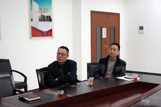 图5、宏陶抛光砖销售副总张彦（左一）、宏陶广东线销售副总庞永江（右一）认真观看参评专卖店幻灯片播放效果