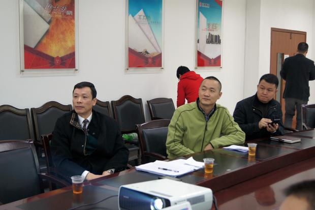 图6、观看幻灯片的同时，宏陶仿古砖副总曹刚毅（右一）特别用手机记下专卖店装修效果的不同亮点